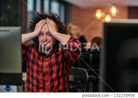 Disappointed Programmer with Messy Hair Looking at Computer Monitor in Office. Disappointed Programmer with Messy Hair Looking at Computer Monitor in Office. 132278456