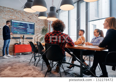 African-American businessman leads a meeting, passionately presenting a business plan to his attentive team, fostering collaboration and strategic thinking African-American businessman leads a meeting, passionately presenting a business plan to his attentive team, fostering collaboration and strategic thinking 132278472