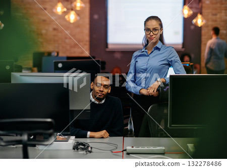 Digital Collaboration: Blonde Businesswoman and African American Partner Reviewing Documents Online 132278486
