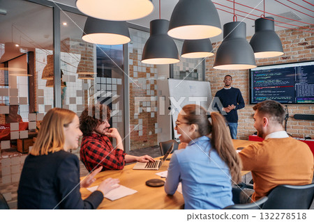 African-American businessman leads a meeting, passionately presenting a business plan to his attentive team, fostering collaboration and strategic thinking 132278518