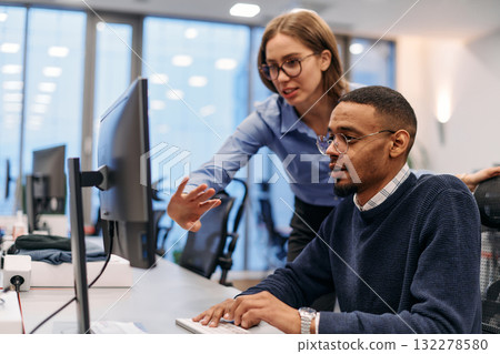 Digital Collaboration: Blonde Businesswoman and African American Partner Reviewing Documents Online 132278580