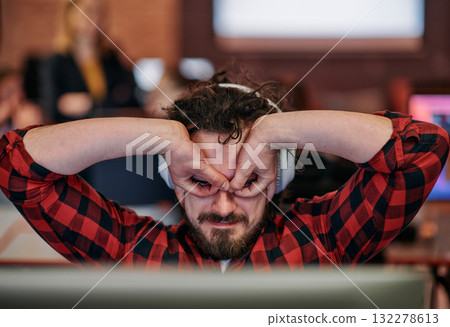 Joyful Collaboration: A Man Embracing Remote Work with Enthusiastic Gestures in a Coworking Space. 132278613