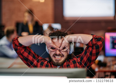 Joyful Collaboration: A Man Embracing Remote Work with Enthusiastic Gestures in a Coworking Space. 132278618