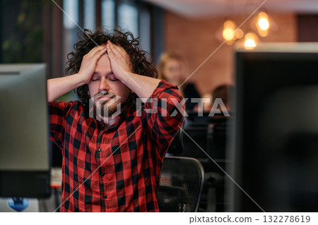 Disappointed Programmer with Messy Hair Looking at Computer Monitor in Office. Disappointed Programmer with Messy Hair Looking at Computer Monitor in Office. 132278619