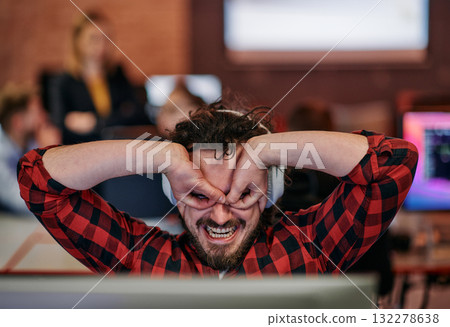 Joyful Collaboration: A Man Embracing Remote Work with Enthusiastic Gestures in a Coworking Space. 132278638