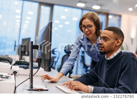 Digital Collaboration: Blonde Businesswoman and African American Partner Reviewing Documents Online 132278780