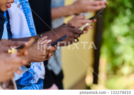 Diverse Teen Group Standing Together Against Wall Using Smartphones Diverse Teen Group Standing Together Against Wall Using Smartphones 132278810
