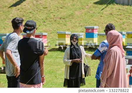 A diverse group of young friends and entrepreneurs explore small honey production businesses in the natural setting of the countryside. A diverse group of young friends and entrepreneurs explore small honey production businesses in the natural setting of the countryside. 132278822