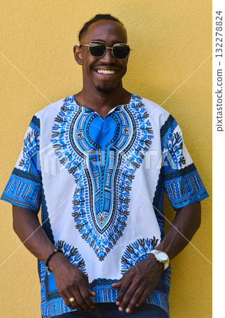 Sudanese Tradition Meets Modern Youth: African American Teen in Vibrant Traditional Attire Against a Yellow Backdrop 132278824