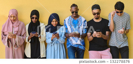 Diverse Teen Group Standing Together Against Wall Using Smartphones Diverse Teen Group Standing Together Against Wall Using Smartphones 132278876