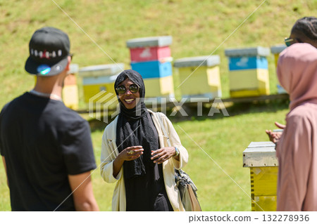 A diverse group of young friends and entrepreneurs explore small honey production businesses in the natural setting of the countryside. A diverse group of young friends and entrepreneurs explore small honey production businesses in the natural setting of the countryside. 132278936