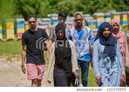 A diverse group of young friends and entrepreneurs explore small honey production businesses in the natural setting of the countryside. 132278958