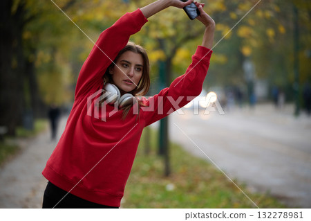 Athletic young woman taking a breath and relaxing after jogging and stretching. Woman Training and Workout Exercises On Street. Athletic young woman taking a breath and relaxing after jogging and stretching. Woman Training and Workout Exercises On Street. 132278981