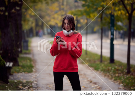 Athletic young woman taking a breath and relaxing after jogging and stretching. Woman Training and Workout Exercises On Street. Athletic young woman taking a breath and relaxing after jogging and stretching. Woman Training and Workout Exercises On Street. 132279000