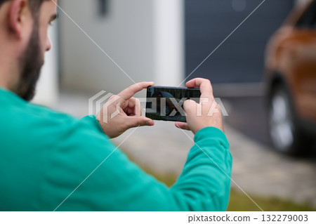 Capturing the Moment: A Man Photographs His Car for Sale to Share Online 132279003