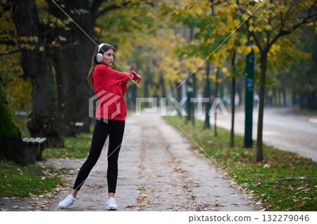 Athletic young woman taking a breath and relaxing after jogging and stretching. Woman Training and Workout Exercises On Street. 132279046