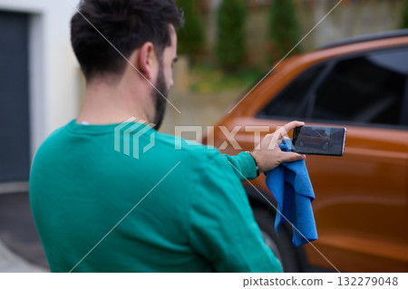 Capturing the Moment: A Man Photographs His Car for Sale to Share Online 132279048