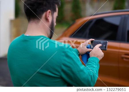 Capturing the Moment: A Man Photographs His Car for Sale to Share Online 132279051