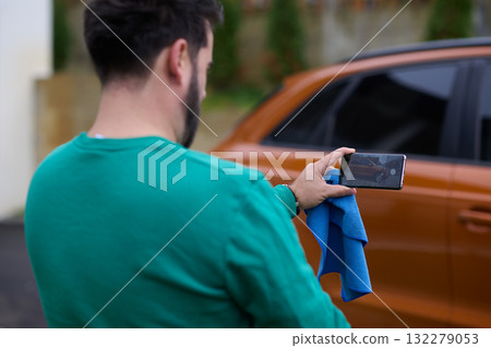 Capturing the Moment: A Man Photographs His Car for Sale to Share Online 132279053