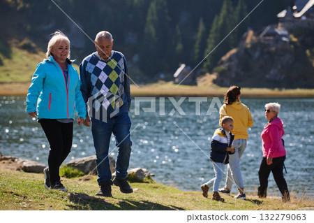A family shares delightful moments with their friends amid the stunning landscapes of mountains, lakes, and winding paths, promoting a healthy lifestyle and the joy of familial bonds in the embrace of A family shares delightful moments with their friends amid the stunning landscapes of mountains, lakes, and winding paths, promoting a healthy lifestyle and the joy of familial bonds in the embrace of 132279063