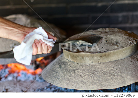 Capturing the essence of Bosnian culinary tradition, step-by-step preparation of a traditional Bosnian pie, showcasing the meticulous craftsmanship and authentic flavors involved in the culinary 132279069