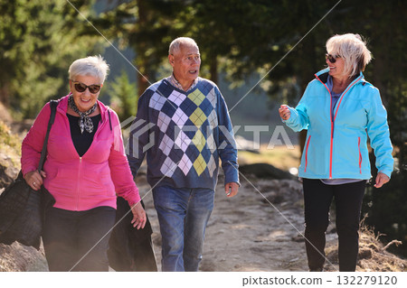 A family shares delightful moments with their friends amid the stunning landscapes of mountains, lakes, and winding paths, promoting a healthy lifestyle and the joy of familial bonds in the embrace of 132279120