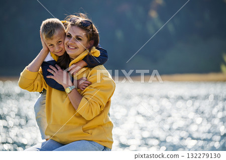 A mother and son create cherished memories as they playfully engage in outdoor activities, their laughter echoing the joy of shared moments and the bond between parent and child 132279130