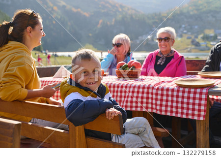 A family on a mountain vacation indulges in the pleasures of a healthy life, savoring traditional pie while surrounded by the breathtaking beauty of nature, fostering family bonds and embracing the A family on a mountain vacation indulges in the pleasures of a healthy life, savoring traditional pie while surrounded by the breathtaking beauty of nature, fostering family bonds and embracing the 132279158