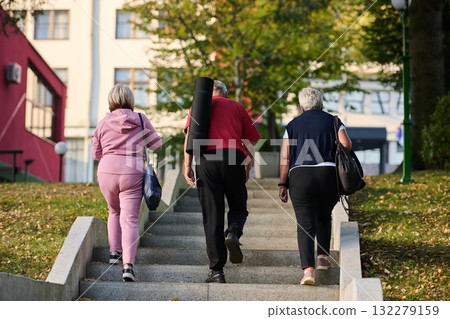 A group of senior friends takes a well-deserved break in nature, fostering not only fitness but also camaraderie and a shared commitment to maintaining a healthy and active lifestyle in their golden A group of senior friends takes a well-deserved break in nature, fostering not only fitness but also camaraderie and a shared commitment to maintaining a healthy and active lifestyle in their golden 132279159