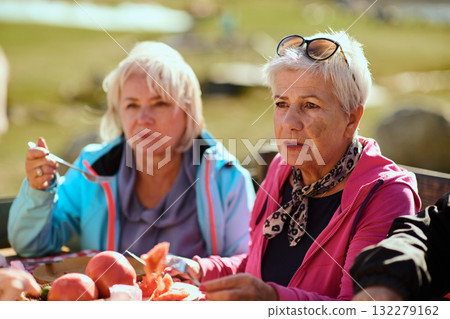 A family on a mountain vacation indulges in the pleasures of a healthy life, savoring traditional pie while surrounded by the breathtaking beauty of nature, fostering family bonds and embracing the A family on a mountain vacation indulges in the pleasures of a healthy life, savoring traditional pie while surrounded by the breathtaking beauty of nature, fostering family bonds and embracing the 132279162