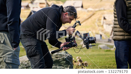 A skilled videographer, equipped with professional gear, captures the essence of nature's beauty, expertly documenting the scenic landscape in a cinematic masterpiece that reflects the seamless blend A skilled videographer, equipped with professional gear, captures the essence of nature's beauty, expertly documenting the scenic landscape in a cinematic masterpiece that reflects the seamless blend 132279170