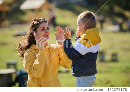 A mother and son create cherished memories as they playfully engage in outdoor activities, their laughter echoing the joy of shared moments and the bond between parent and child A mother and son create cherished memories as they playfully engage in outdoor activities, their laughter echoing the joy of shared moments and the bond between parent and child 132279178