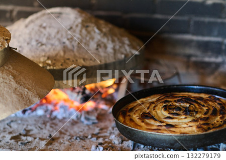 Capturing the essence of Bosnian culinary tradition, step-by-step preparation of a traditional Bosnian pie, showcasing the meticulous craftsmanship and authentic flavors involved in the culinary Capturing the essence of Bosnian culinary tradition, step-by-step preparation of a traditional Bosnian pie, showcasing the meticulous craftsmanship and authentic flavors involved in the culinary 132279179