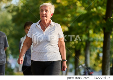A group of senior friends takes a well-deserved break in nature, fostering not only fitness but also camaraderie and a shared commitment to maintaining a healthy and active lifestyle in their golden A group of senior friends takes a well-deserved break in nature, fostering not only fitness but also camaraderie and a shared commitment to maintaining a healthy and active lifestyle in their golden 132279196