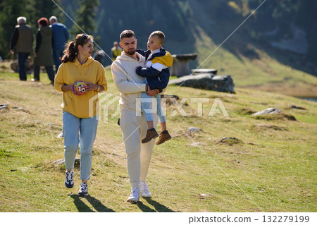 A modern family, along with their son, revels in the joy of a muddy day in nature, running and playing together, encapsulating the beauty of a healthy and active lifestyle A modern family, along with their son, revels in the joy of a muddy day in nature, running and playing together, encapsulating the beauty of a healthy and active lifestyle 132279199