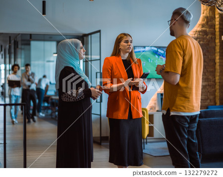 A group of young business colleagues, including a woman in a hijab, stands united in the modern corridor of a spacious startup coworking center, representing diversity and collaborative spirit A group of young business colleagues, including a woman in a hijab, stands united in the modern corridor of a spacious startup coworking center, representing diversity and collaborative spirit 132279272