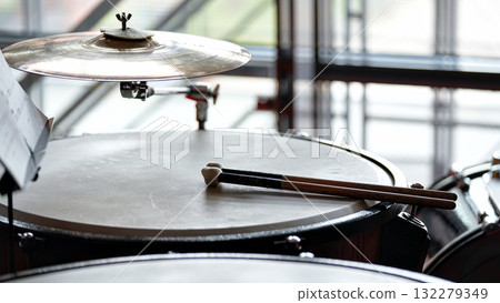 Drum kit with cymbal and drumsticks in bright rehearsal space Drum kit with cymbal and drumsticks in bright rehearsal space 132279349