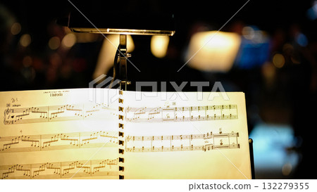 Musical score with clip light and bokeh background at orchestra rehearsal Musical score with clip light and bokeh background at orchestra rehearsal 132279355