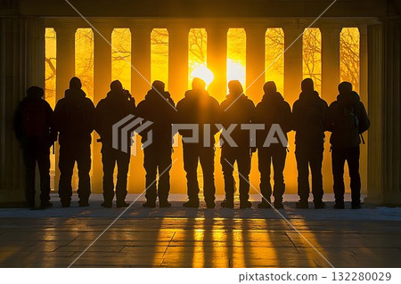 Silhouetted figures stand against a golden sunset framed by clas 132280029
