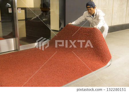 A man replacing a mat at the office entrance A man replacing a mat at the office entrance 132280151