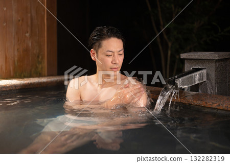A man entering a hot spring 132282319
