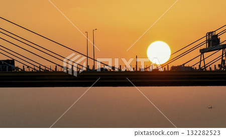 Oct 7 2025 Sunset Over Bridge With Silhouetted Bus, Cables, And Industrial Structures Oct 7 2025 Sunset Over Bridge With Silhouetted Bus, Cables, And Industrial Structures 132282523