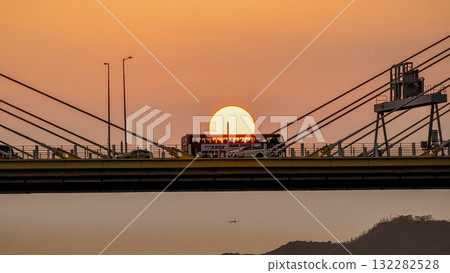 Oct 7 2025 Sunset Over Bridge With Silhouetted Bus, Cables, And Industrial Structures 132282528