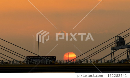 Oct 7 2025 Sunset Over Bridge With Silhouetted Bus, Cables, And Industrial Structures 132282541