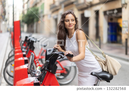 Young woman rents an electric bike on street 132282568