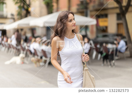 Young woman looks around at street cafes Young woman looks around at street cafes 132282573