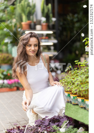 Young woman looks around at street flower shop Young woman looks around at street flower shop 132282574