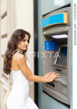 Young woman enters her ATM PIN code 132282598