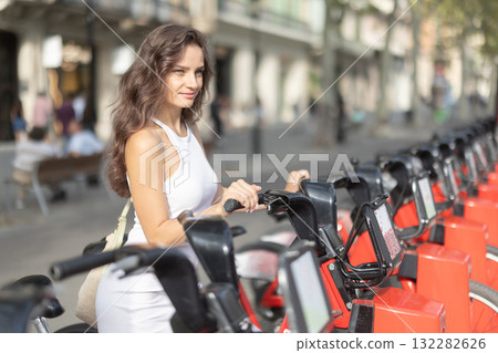 Young woman rents an electric bike on street 132282626