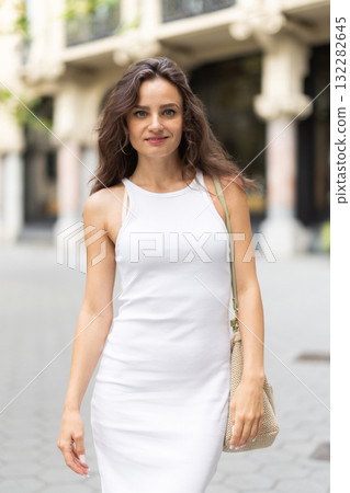 Young woman walks along city street Young woman walks along city street 132282645